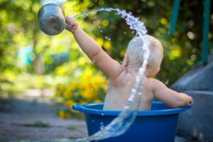 Toddler in bucket throwing water