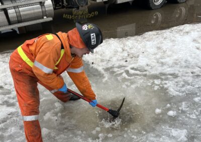 Worker clearing ice from the stormwater drain