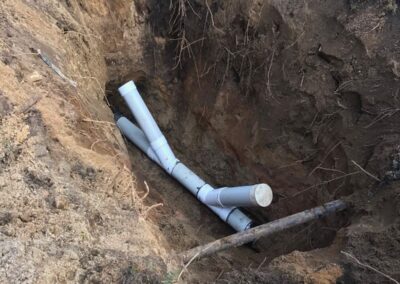 Newly installed PVC drainage or sewer pipes inside an excavation trench.